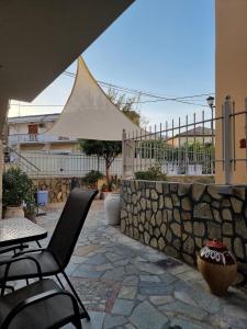 Un patio con mesa y sillas y una valla. en Aeolus Apartment II, en Galaxidhion
