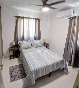 a bedroom with a bed with a striped blanket at Pool Feelings Luxury Edition in Punta Cana