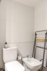 Un baño blanco con inodoro y lavabo. en In the heart of Montevideo - Modern and comfortable!, en Montevideo 20 fotos más