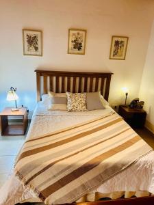 une chambre avec un grand lit avec une tête de lit en bois dans l'établissement Alojamiento Santa Rita, à Santo Tomé