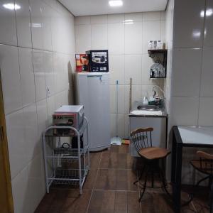 een keuken met een koelkast en een tafel en stoelen bij Hospedaria Dona Clara in Tiradentes