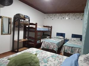 a room with three bunk beds and a mirror at Casa para 12 pessoas perto da Basílica e da Feira in Aparecida