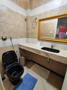 ein Badezimmer mit Toilette, Waschbecken und Spiegel in der Unterkunft Casa Aconchego in Aracaju + 17 Fotos