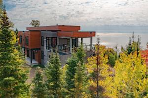 ein Haus auf einem Hügel mit Bäumen in der Unterkunft Le Saint-Laurent in Petite-Rivière-Saint-François