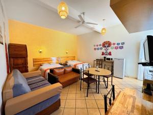 a living room with two beds and a table at Hotel Escalada in Oaxaca City