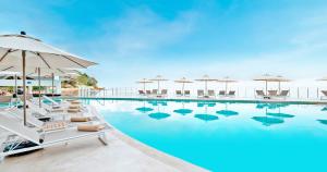 a swimming pool with lounge chairs and umbrellas at Grand Park Royal Puerto Vallarta - All Inclusive in Puerto Vallarta