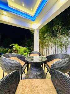 a patio with wicker chairs and a glass table at Tomeizah in Sampong +36 photos