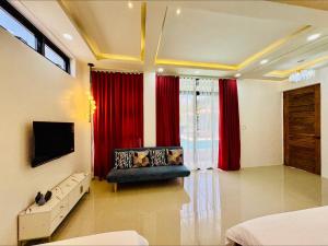 a living room with a couch and red curtains at Tomeizah in Sampong