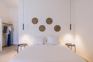 1 dormitorio con 1 cama blanca y 2 cestas en la pared en Ziran Resort, en Noto