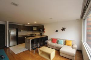 a living room with a couch and a kitchen at Finlandia Park Suite in Quito +50 photos