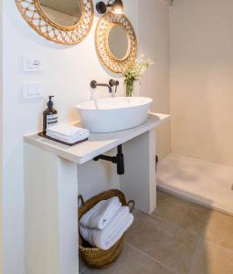 Un baño con un lavabo y un espejo en la pared. en Ziran Resort, en Noto