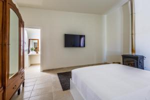 a bedroom with a bed and a tv on a wall at Ziran in Noto
