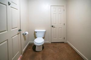 a bathroom with a white toilet and a door at Moab Adventure Basecamp in Moab