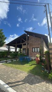 a brick house with blue chairs in front of it at Casa da Serra Bananeiras in Bananeiras