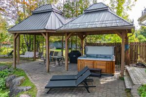a large wooden gazebo with a pool table at Waterfront with VIEW and SPA in Saint-Raymond