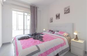 a bedroom with a pink and white bed with a window at Awesome Apartment In Torrevieja in Torrevieja