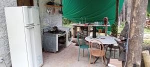 una cucina con piano cottura, tavolo e sedie di Suítes Águas do Estaleiro a Ubatuba