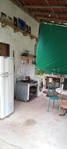 una cucina con frigorifero, tavolo e sedia di Suítes Águas do Estaleiro a Ubatuba