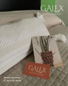 a bed with a pillow and a sign that says cale hotel roomarden at Galex Hotel Posada in Huajuapan de León
