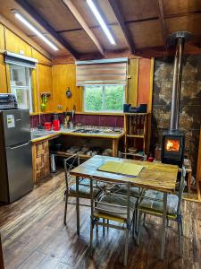 a kitchen with a table with chairs and a stove at Cabañas Tranquihue Llifen in llifen +9 photos
