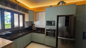 a kitchen with a stainless steel refrigerator and a sink at Casa da Serra Bananeiras in Bananeiras