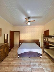 a bedroom with a bed and a ceiling fan at Chácara Renil in Olímpia +98 photos