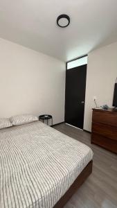 a bedroom with a bed and a black door at Departamento equipado a 10 minutos de la playa in Santa Cruz Huatulco