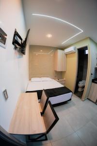 una pequeña habitación con una cama y una mesa en Experience Medellín's Comuna 13 INT401, en Medellín
