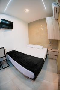 Un dormitorio con una cama y un televisor en la pared. en Experience Medellín's Comuna 13 INT401, en Medellín