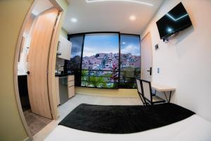 Un dormitorio con una cama y una ventana grande. en Experience Medellín's Comuna 13 INT401, en Medellín