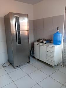 a kitchen with a stainless steel refrigerator and a counter at Encantos do Natal em Garanhuns in Garanhuns