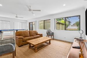 una sala de estar con un sofá y una mesa en Currimundi Lake House, en Kawana Waters