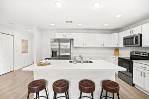 eine Küche mit einer großen weißen Insel mit Barhockern in der Unterkunft Chic & Central 3br Mins To Downtown in West Palm Beach