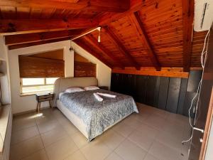a bedroom with a bed in a room with wooden ceilings at Five Stars Villa09 in Hod HaSharon