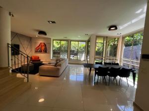 a living room with a couch and a table and chairs at Five Stars Villa09 in Hod HaSharon