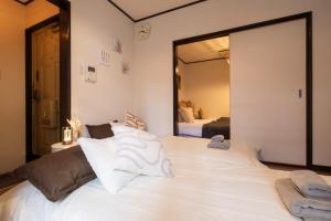 1 cama blanca grande en una habitación con espejo en Nihonbashi GRR5, en Osaka 37 fotos más