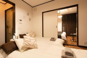 Un dormitorio con una gran cama blanca con un gran espejo. en Nihonbashi GRR5, en Osaka