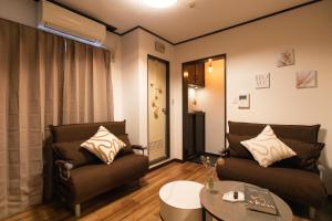 Una sala de estar con dos sofás y una mesa. en Nihonbashi GRR5, en Osaka