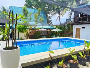 GinatilanMolinillo Vacation Cabin的一座种植了植物的游泳池,位于一座房子旁边