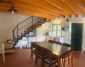 a kitchen and dining room with a table and a staircase at Granero Chacras in Ciudad Lujan de Cuyo