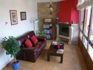 a living room with a leather couch and a fireplace at Casa da Balea in Corcubión