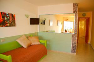 a living room with a green couch and a mirror at Turas Club Case Vacanze in Bosa