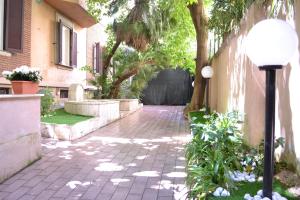 a brick walkway with a street light next to a house at Tiburtina House in Rome