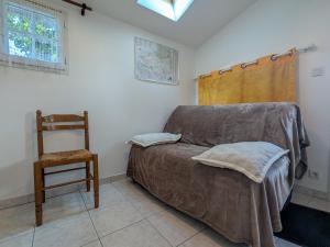 a bedroom with a bed and a chair and a window at Chambres d'hôtes avec jardin près des châteaux de la Loire - FR-1-591-666 in Châtillon-sur-Indre
