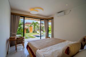 een slaapkamer met een groot bed en een groot raam bij NEW! Tropical Palms Villa - 4BR Villa in Kerobokan in Kerobokan +216 foto's