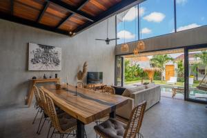 een woonkamer met een houten tafel en een bank bij NEW! Tropical Palms Villa - 4BR Villa in Kerobokan in Kerobokan