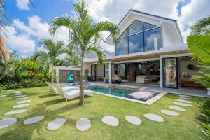 een huis met een zwembad en een palmboom bij NEW! Tropical Palms Villa - 4BR Villa in Kerobokan in Kerobokan