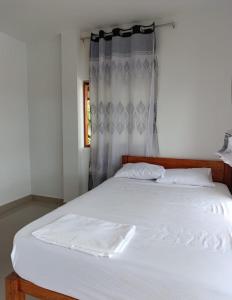 ein Schlafzimmer mit einem weißen Bett mit einem Fenster in der Unterkunft CASA de PLAYA con PISCINA FRENTE al MAR in Bocapán