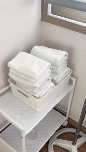 una pila de toallas en un estante en un baño en Bellus-Rose Pension Gyeongju, en Gyeongju