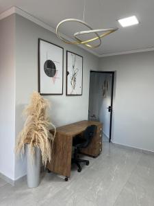 an office with a wooden desk and a chair at Sinta-se em Casa in Cornélio Procópio +1 photo